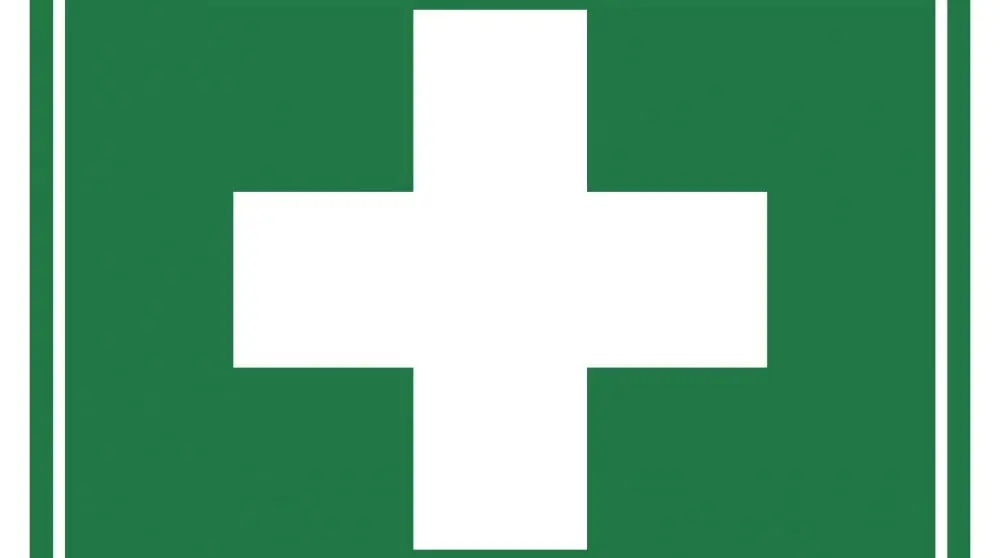 First aid sign with white cross on green background