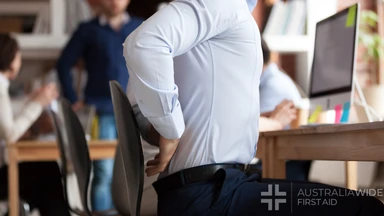 Businessman working sitting at desk feels unhealthy suffers from lower back pain. Damage of intervertebral discs, spinal joints, compression of nerve roots caused by wrong posture and sedentary work